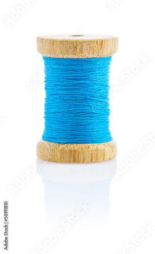 a small wooden bobbin with blue thread