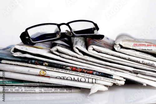 newspapers and eyeglass with reflection