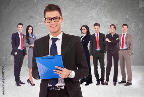 Canvas-taulu Leader holding a clipboard with business team behind