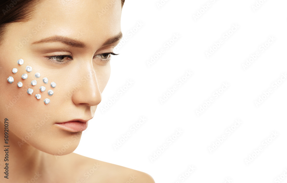 Beautiful face of young woman with cosmetic cream on a cheek Beautiful face of young woman with cosmetic cream on a cheek