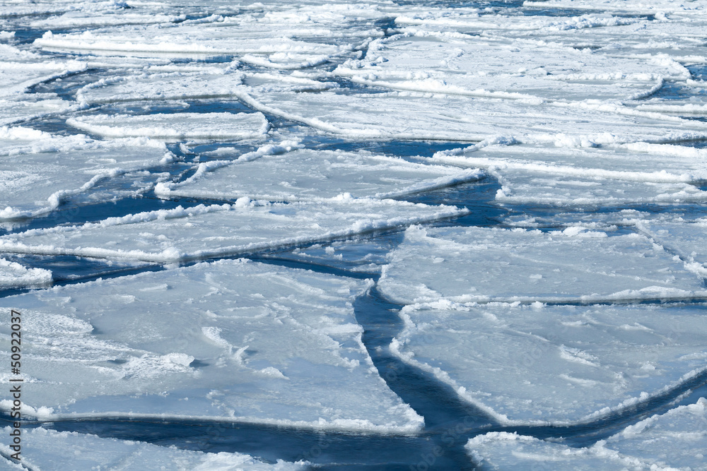 Winter background, blocks of ice on frozen blue Sea