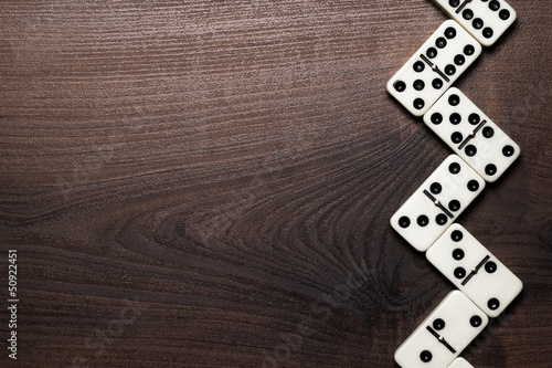 domino pieces forming zigzag over wooden table photo