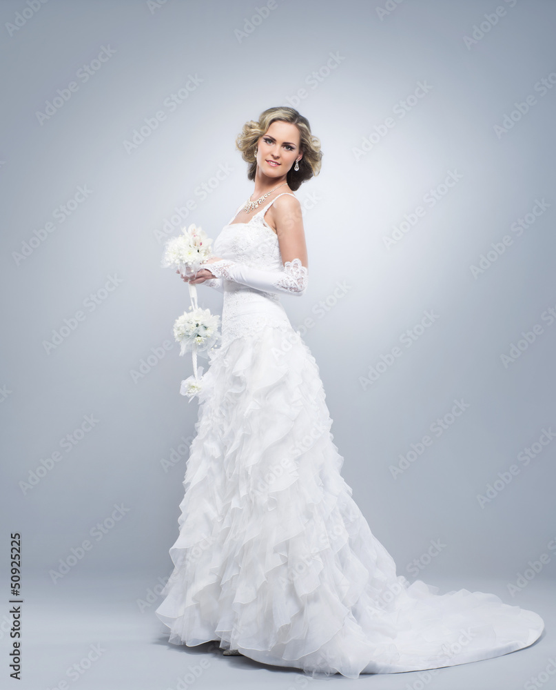 Young and beautiful bride in a dress standing with flowes Young and beautiful bride in a dress standing with flowes
