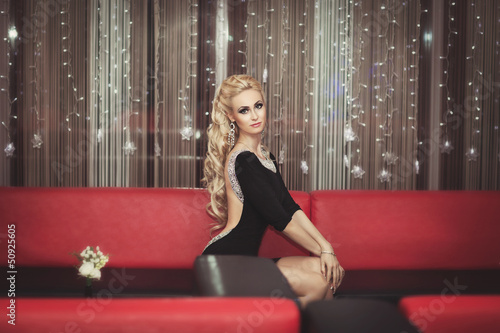 Fashion blonde woman in hotel party. Hairstyle and make up