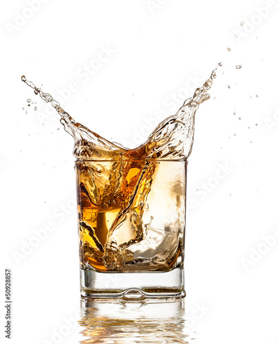 Whiskey glass with splash, isolated on white background