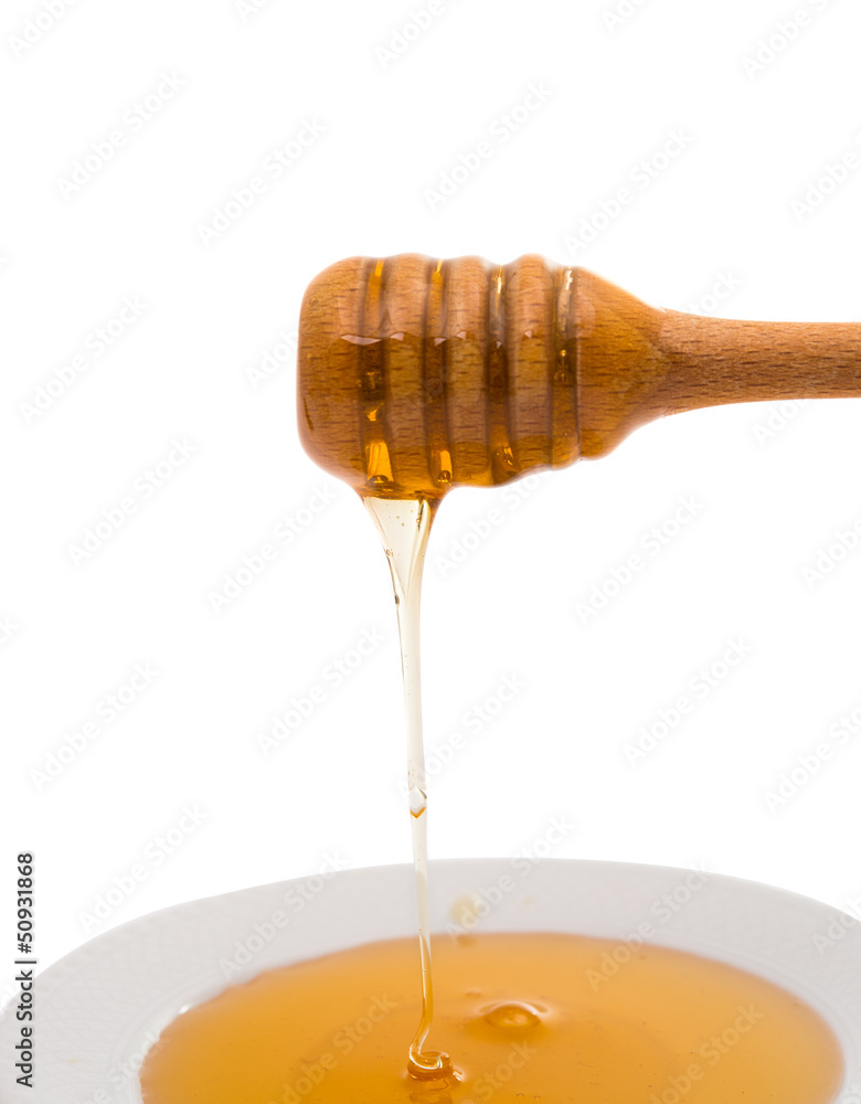 Honey dripping from a wooden honey dipper Honey dripping from a wooden honey dipper