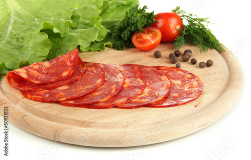 Salami slices on wooden board, isolated on white