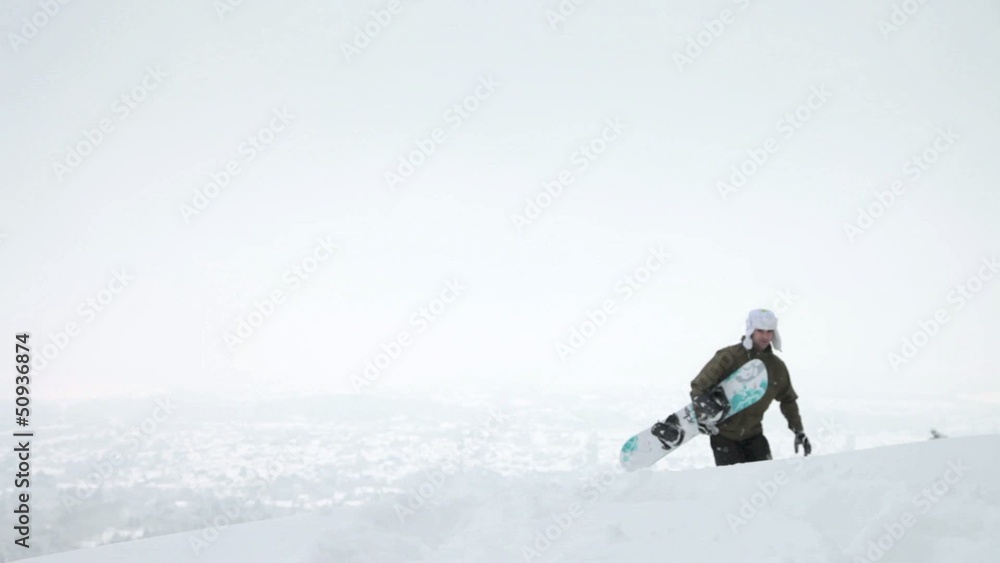 Snowboarder mit Board geht durch den Schnee Snowboarder mit Board geht durch den Schnee