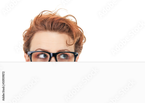 Woman peep out behind blank white board, hide situation