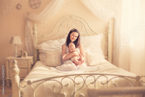 A mother with a newborn baby on the bed © elina_lava