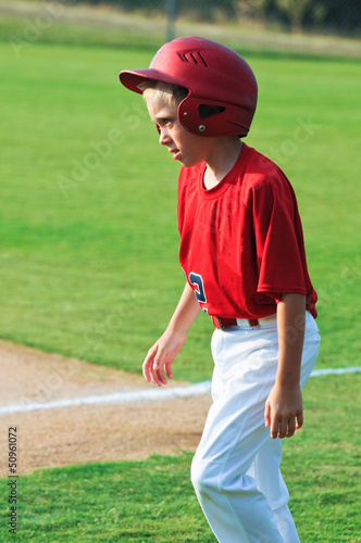 Baseball player walking across field. © tammykayphoto
