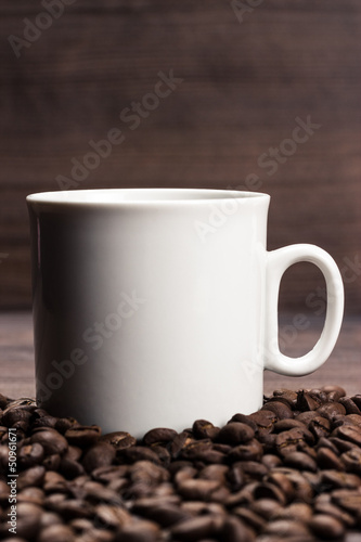 cup of coffee and beans on brown wooden background