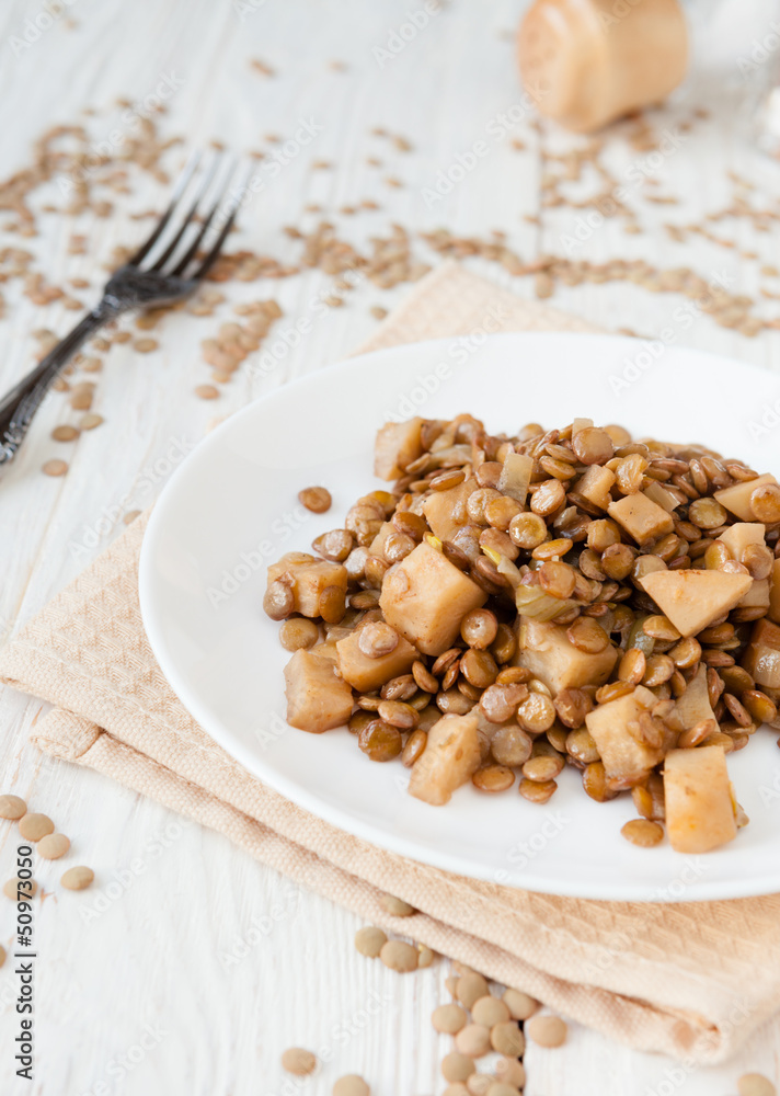 lentil stew with celery on a white plate