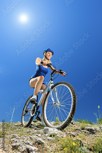 Fototapeta Naklejka Na Ścianę i Meble -  A female biker riding a mountain bike
