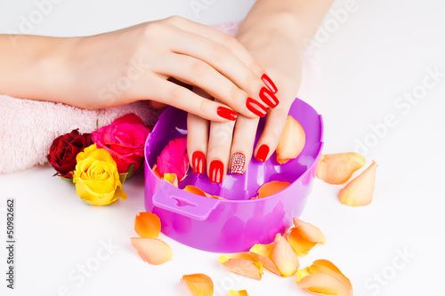 girl with bright red polish on the nails in salon