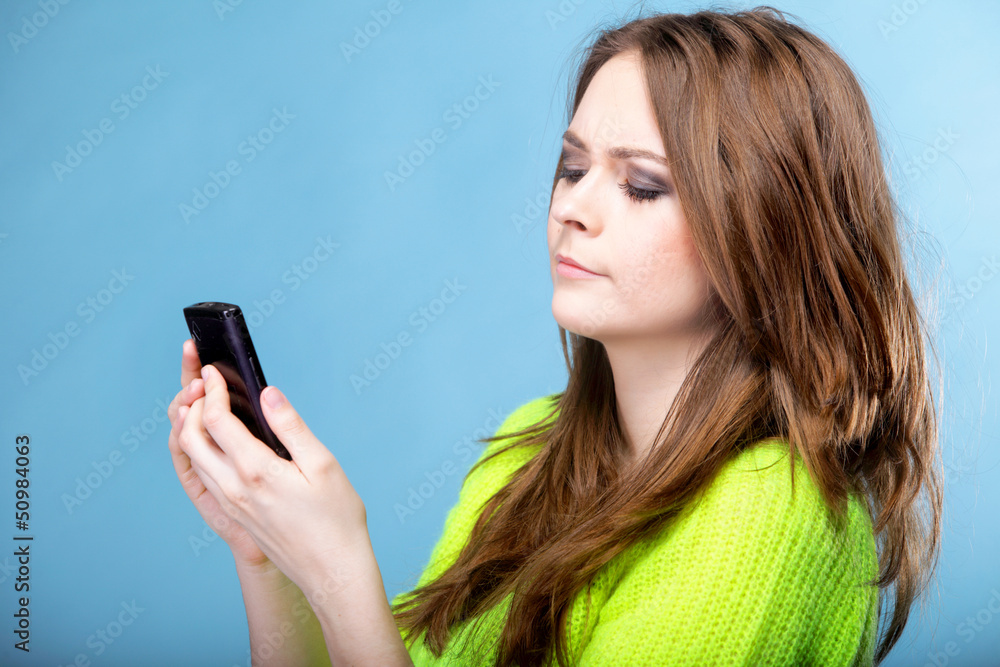Woman texting while looking surprised on phone Woman texting while looking surprised on phone