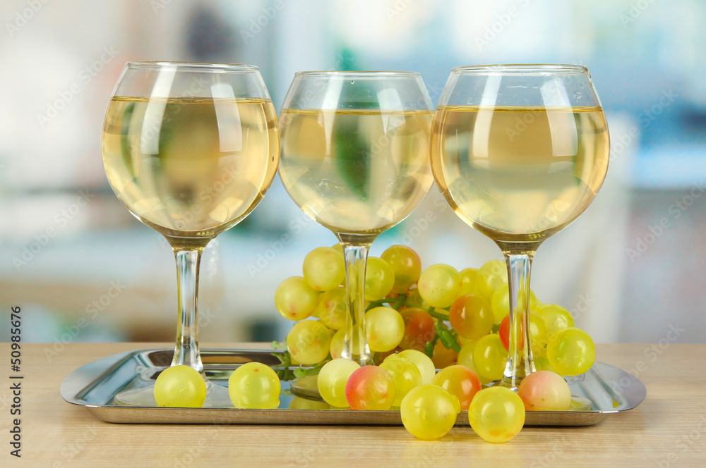 White wine in glass on salver on room background White wine in glass on salver on room background