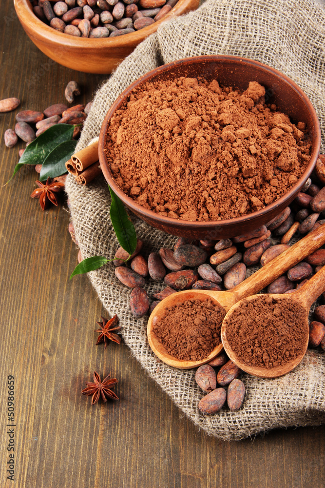 Cocoa powder and cocoa beans on wooden background Cocoa powder and cocoa beans on wooden background