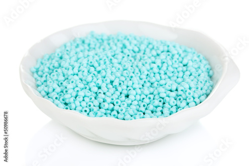 Turquoise beads in white plate isolated on white
