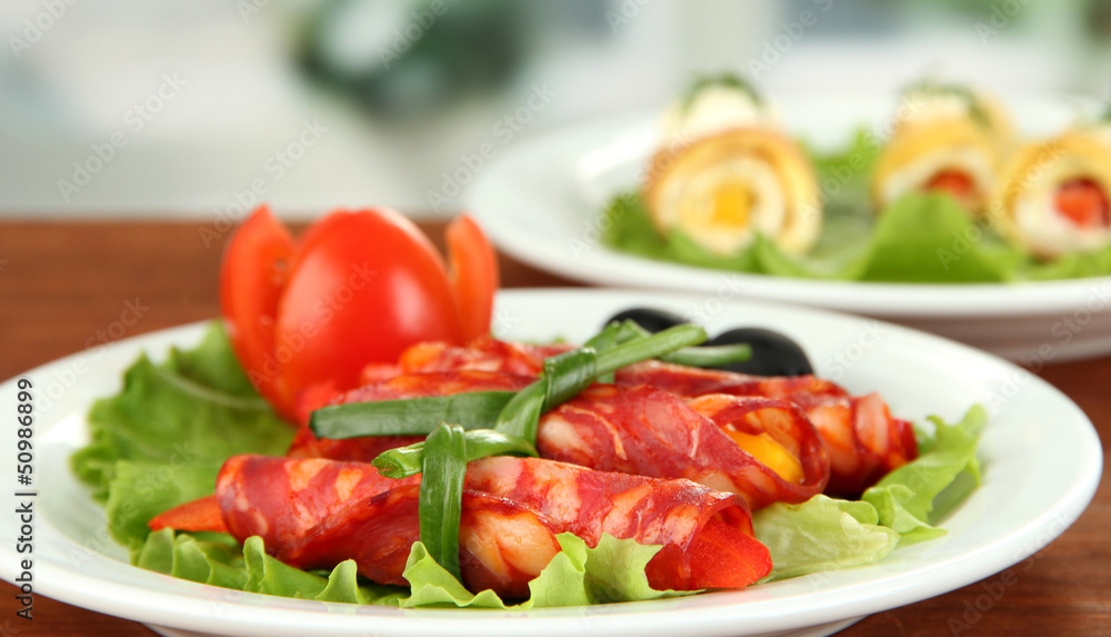 Salami rolls on white plate on bright background Salami rolls on white plate on bright background
