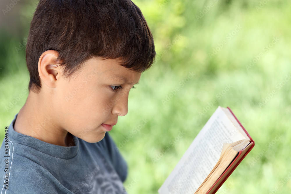 Young boy reading book outside Young boy reading book outside