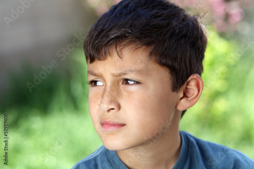 Smiling young boy outside with copy space to left