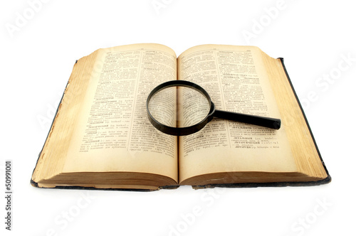 old dictionary book  with a magnifying glass isolated on white b