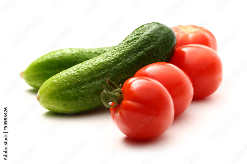 Fresh cucumbers and tomatoes on white Fresh cucumbers and tomatoes on white