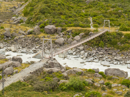 Swing bridge over mountain river in New Zealand