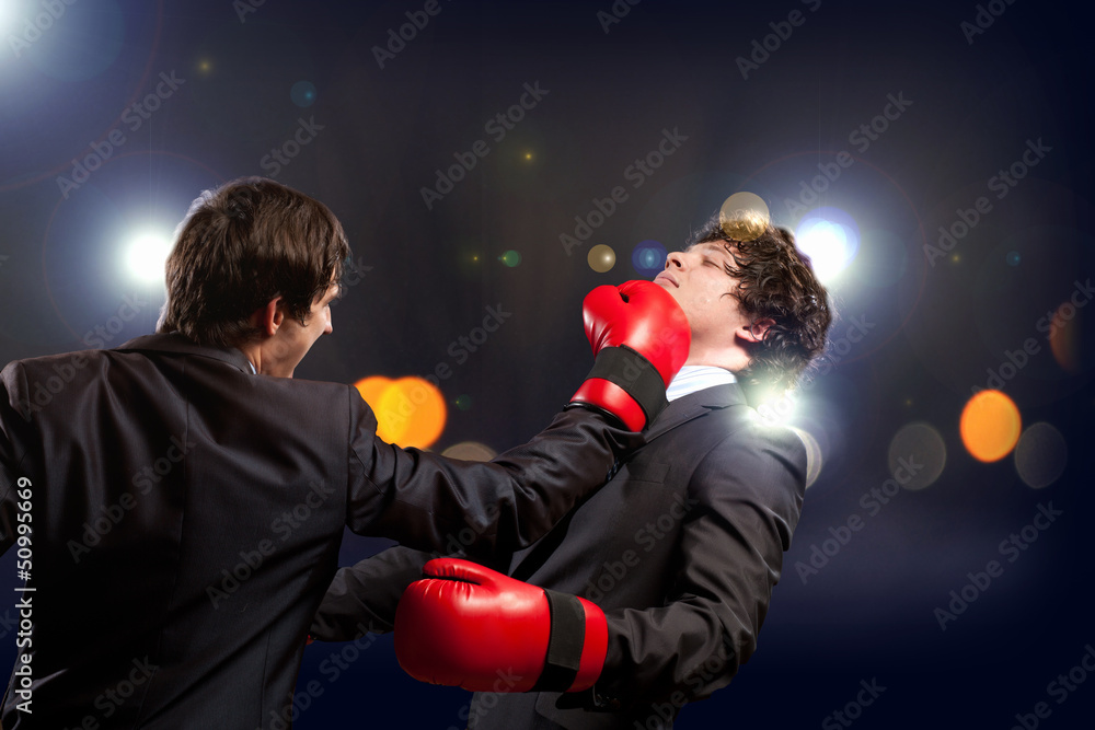 Two young businessman boxing