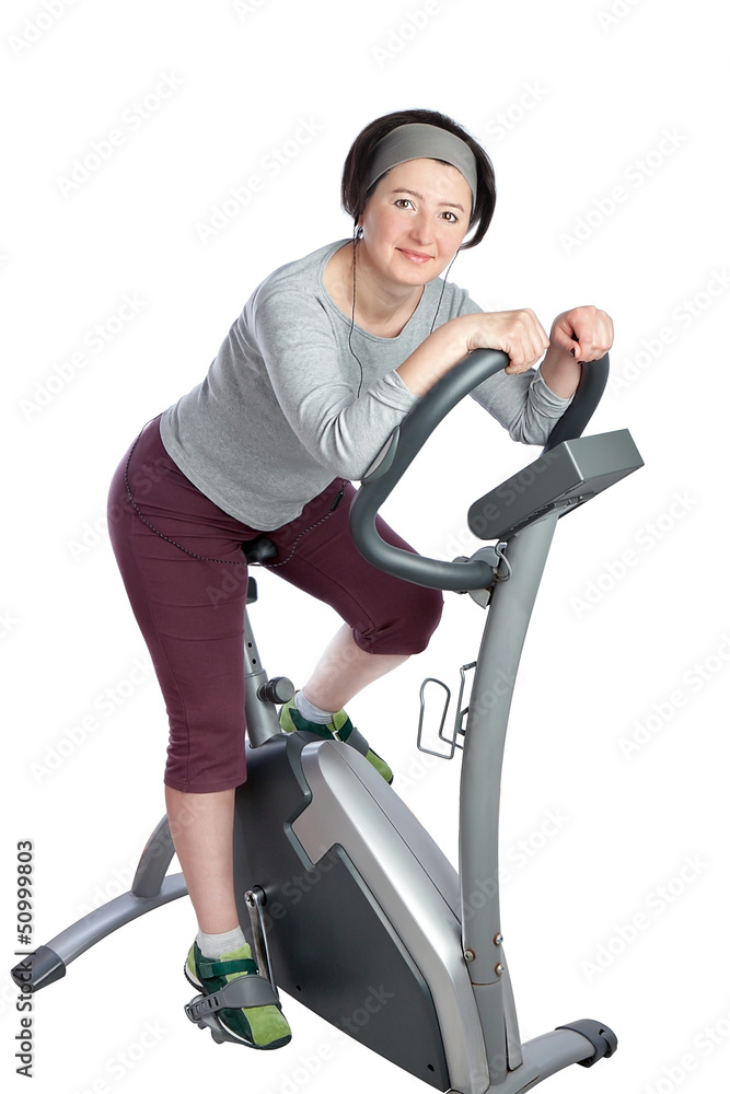Woman, middle-aged on a stationary bike practicing for slimming.