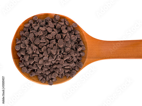 Choc chips for baking on wooden spoon, isolated over white backg