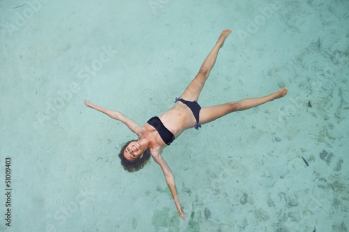 Pretty slim woman in bikini lying on coast Bali