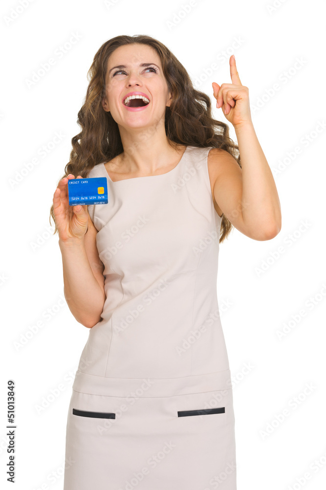 Obraz premium Happy young woman with credit card pointing on copy space
