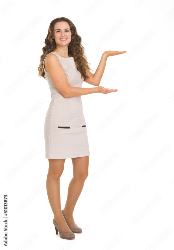 Full length portrait of woman showing something on empty hands Full length portrait of woman showing something on empty hands