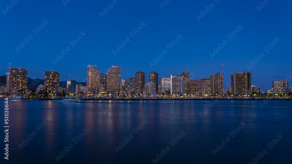 Honolulu downtown at night with seafront Honolulu downtown at night with seafront