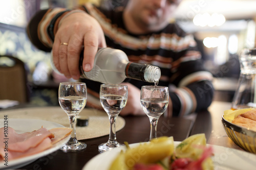 Man pouring vodka in taverna
