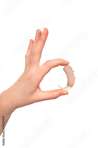 Hearing aid  between hand's fingers. photo