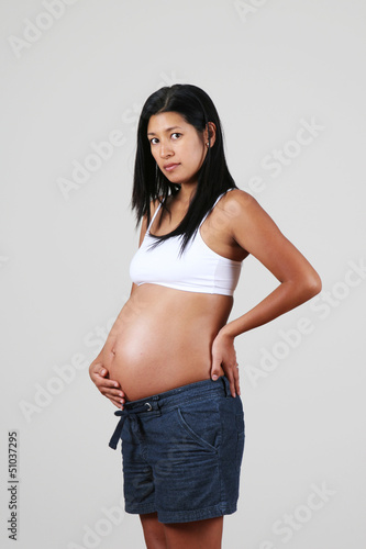 Pregnant Peruvian woman, posing, touching her belly