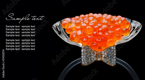 Red caviar in glass isolated on black