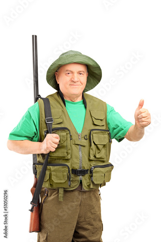 A mature hunter holding a rifle and giving a thumb up