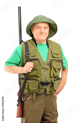 A mature hunter holding a rifle and looking at camera