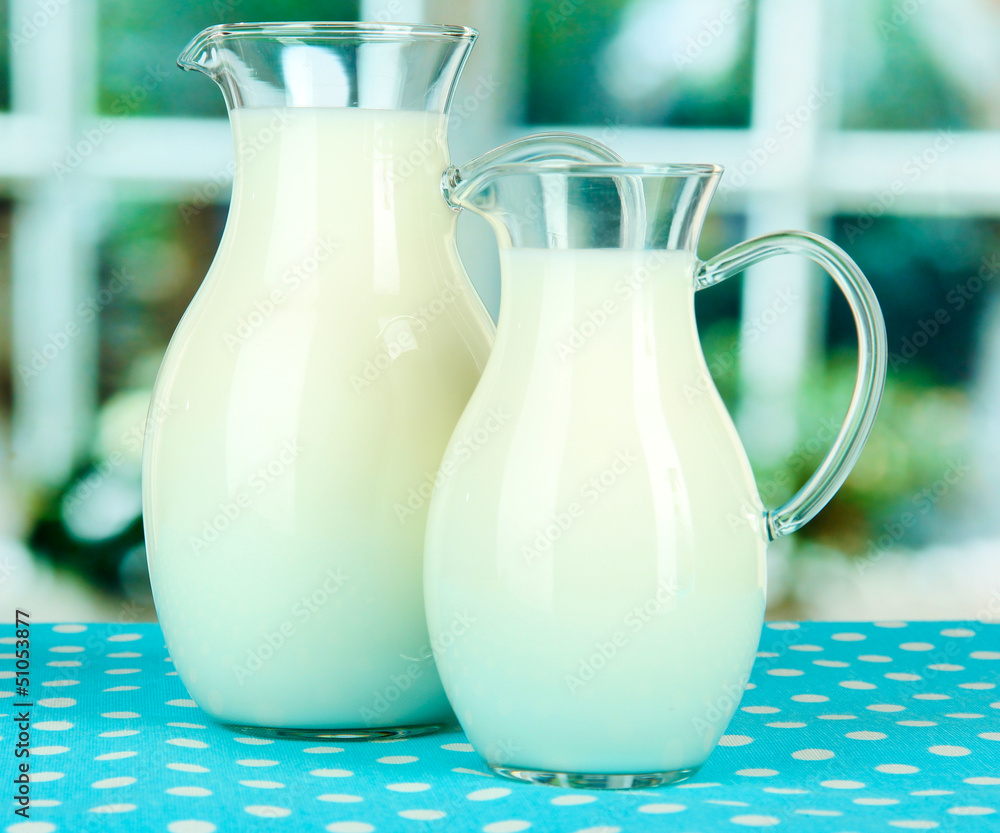 Pitchers of milk on table in room Pitchers of milk on table in room