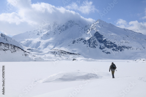 A lone hiker in the cold landscape of Mont Cenis ( France ).