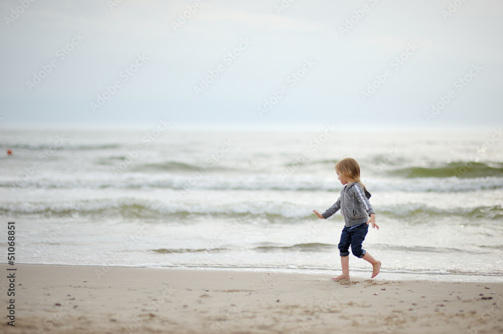 Adorable girl playing on the beach