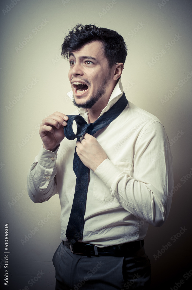 Naklejka premium Sexy stylish businessman adjusting tie