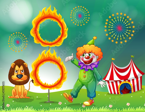 A lion and a clown with a ring of fire