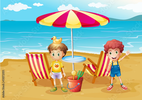 Two boys at the beach near the umbrella and chairs
