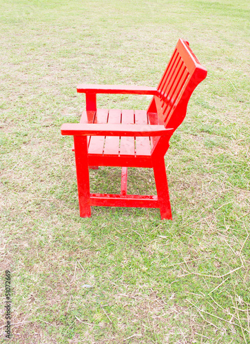 Red wooden chair on gren grass.
