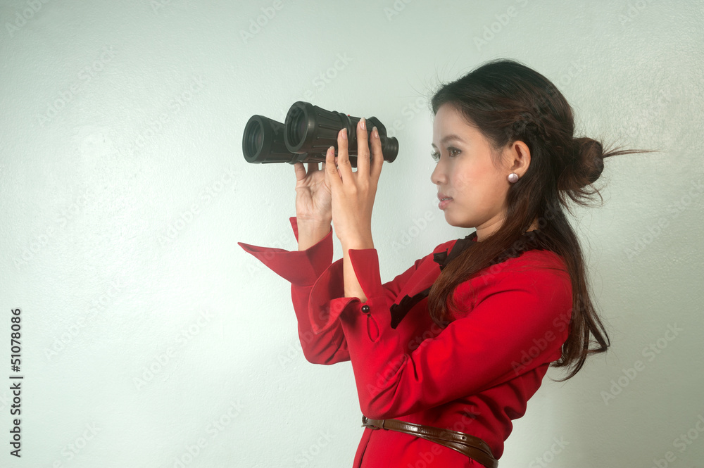 Obraz premium Pretty Asian business woman looking with binoculars .